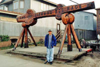Me standing in front of Iditarod Dog Race finish line in Nome, AK